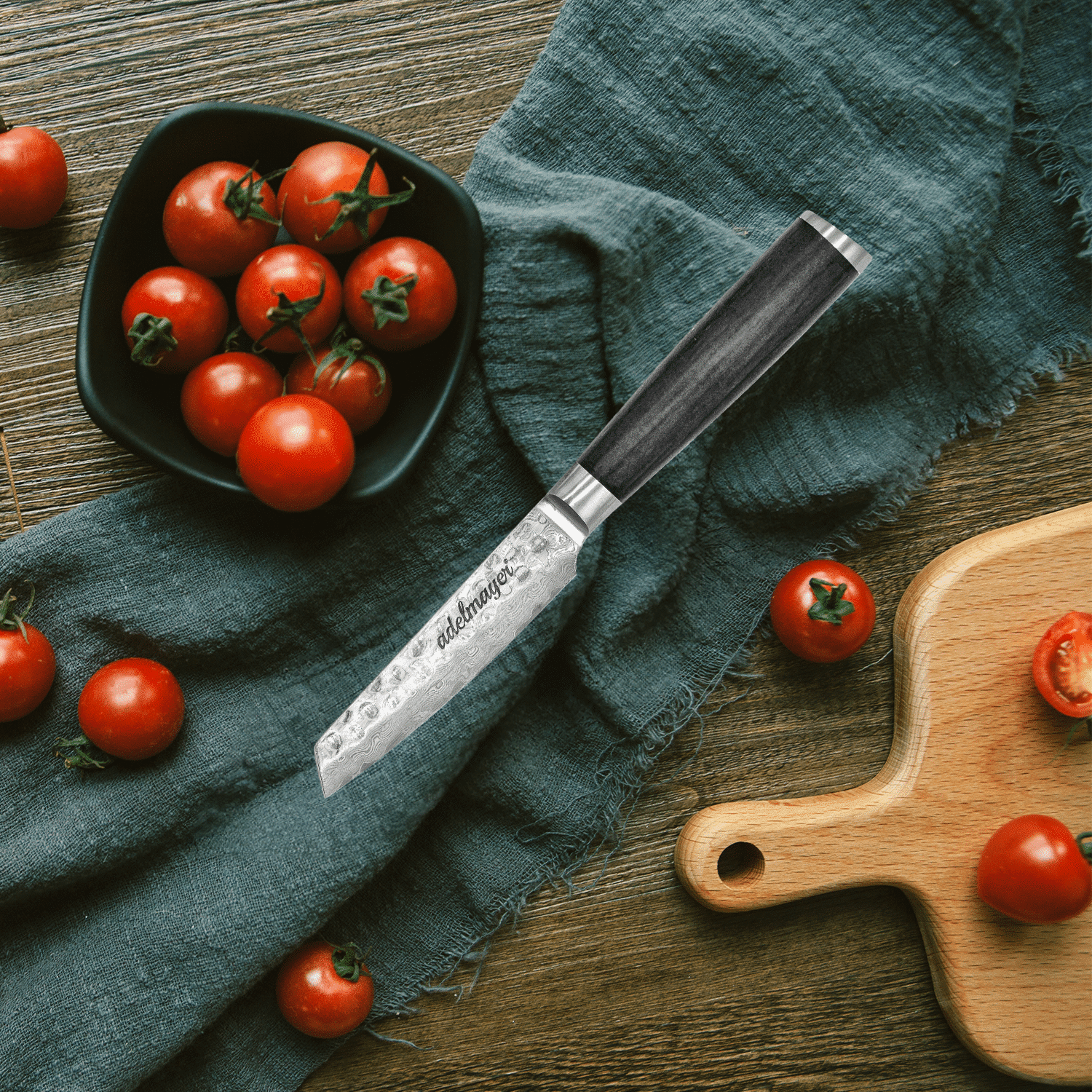 Kitchen knife next to fresh cherry tomatoes.